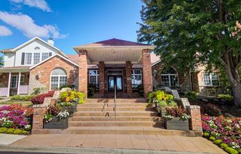the front of a brick house with stairs and a porch